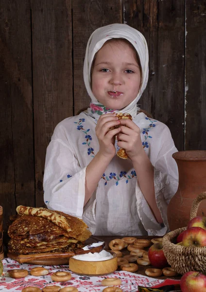 Dziewczyna, jeść placki podczas Maslenitsa — Zdjęcie stockowe