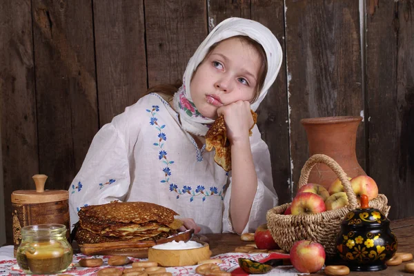 Flicka äter pannkakor under Maslenitsa — Stockfoto