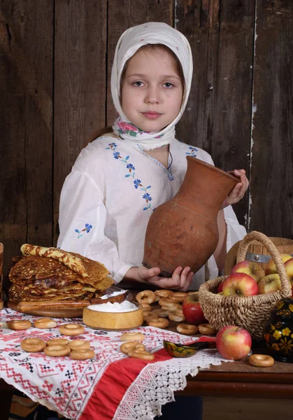 Girl with pancakes and a jug of milk — Stock Photo, Image