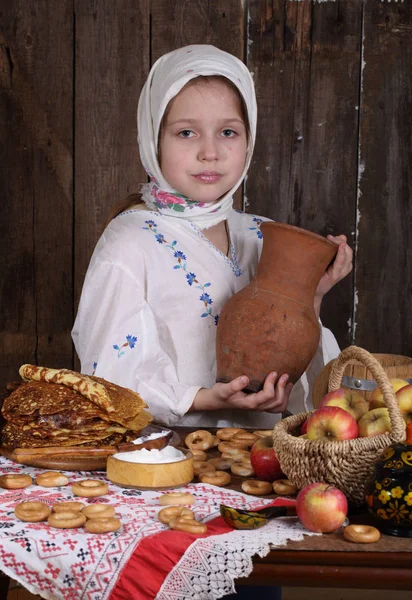 Ragazza con frittelle e una brocca di latte — Foto Stock