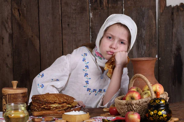 Flicka äter pannkakor under Maslenitsa — Stockfoto