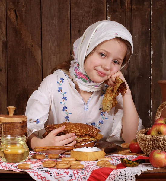 Ragazza mangiare frittelle durante Maslenitsa — Foto Stock