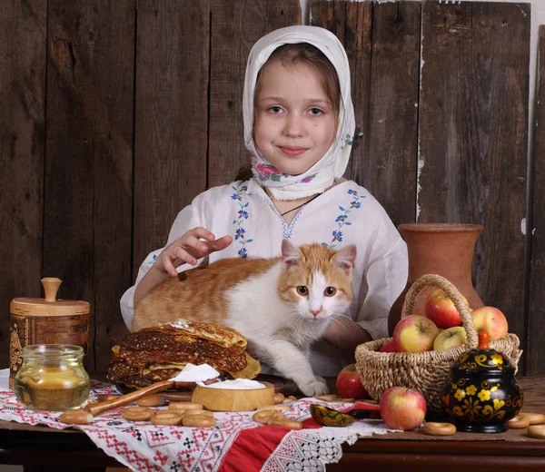 Dívka u stolu dovolená s kočkou. Karneval — Stock fotografie