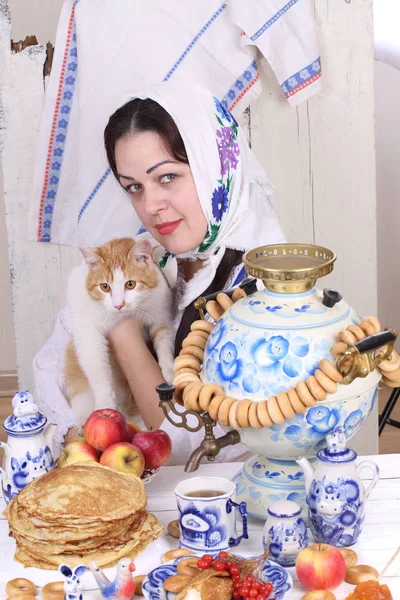 Chica sosteniendo un gato para la mesa de vacaciones . — Foto de Stock