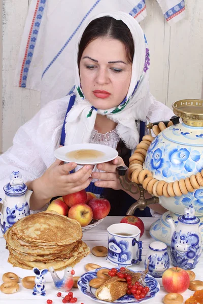 Menina bebendo chá do pires na mesa de férias — Fotografia de Stock