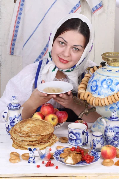Дівчина п'є чай з блюдця за святковим столом — стокове фото