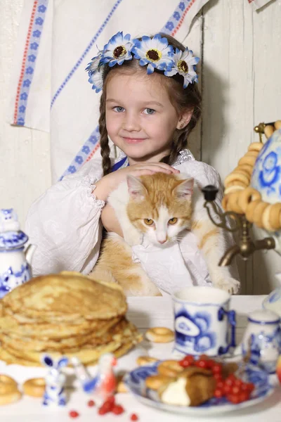 Menina e gengibre gato na mesa — Fotografia de Stock