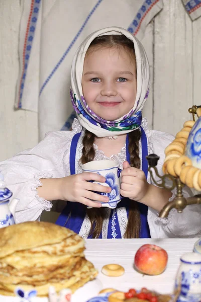 Menina beber chá na mesa de férias — Fotografia de Stock