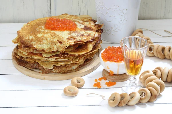 Pancakes with red caviar and tincture on a wooden table — Stock Photo, Image