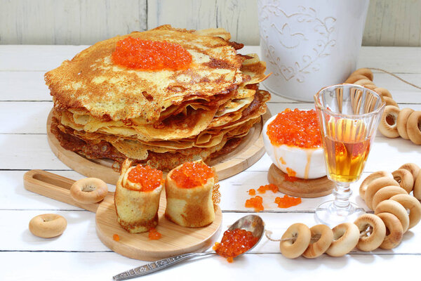 Pancakes with red caviar and tincture in a glass.
