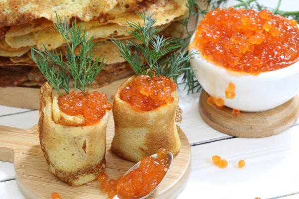 Pancake dengan kaviar merah di atas meja kayu — Stok Foto