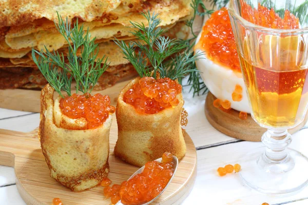 Pancakes with red caviar on a wooden table — Stock Photo, Image