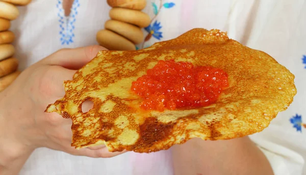Female hands holding a pancake with caviar — Stock Photo, Image