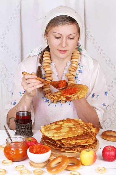 Menina comendo uma panqueca com caviar vermelho — Fotografia de Stock