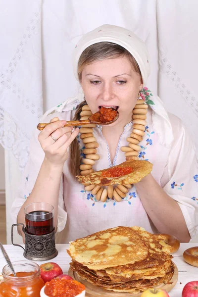 Girl eating pancakes with caviar