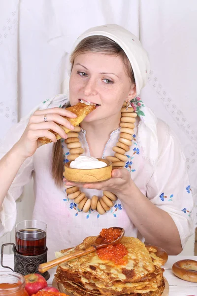 Το κορίτσι στο γιορτινό τραπέζι τρώγοντας τηγανίτες — Φωτογραφία Αρχείου