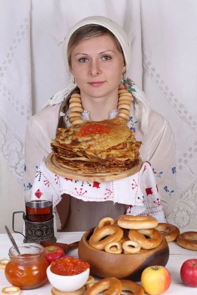 The girl is holding a stack of pancakes with red caviar Stock Photo