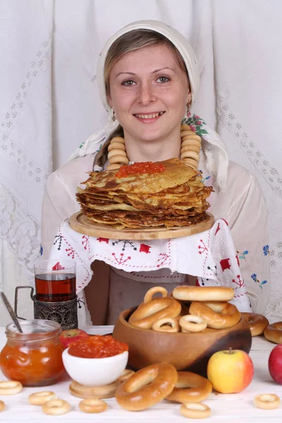 La ragazza sta tenendo una pila di pancake con caviale rosso Fotografia Stock