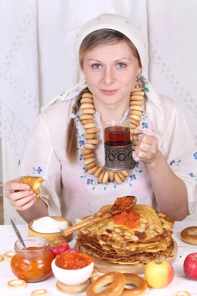 A menina na mesa festiva comendo panquecas e bebendo chá — Fotografia de Stock