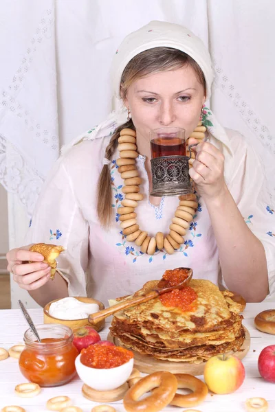 A menina na mesa festiva comer panquecas e beber chá f — Fotografia de Stock