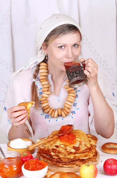 La ragazza al tavolo festivo che mangia frittelle e beve tè — Foto Stock