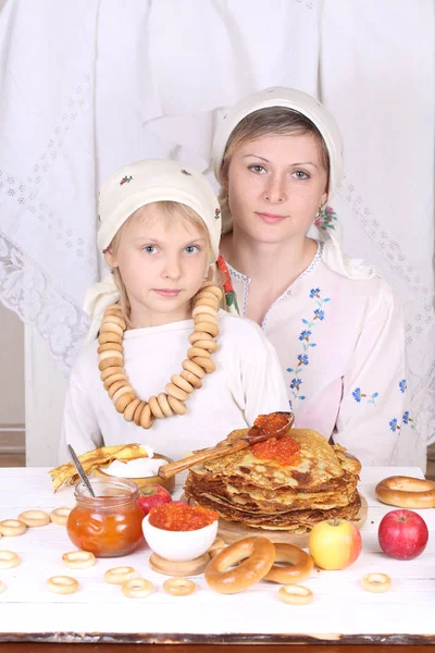 Mamma med dotter äta pannkakor med röd kaviar på semestern ta — Stockfoto