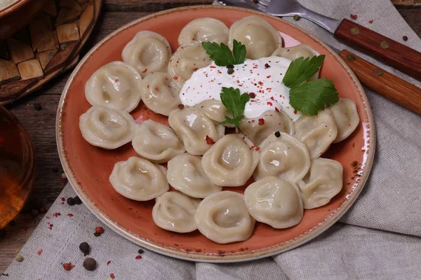 Dumplings with sour cream in a ceramic bowl — Stock Photo, Image