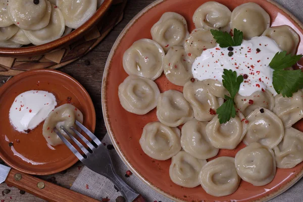 Dumplings with sour cream in a ceramic bowl — Stock Photo, Image