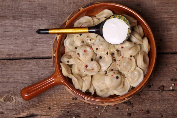 Dumplings with sour cream in a ceramic bowl — Stock Photo, Image