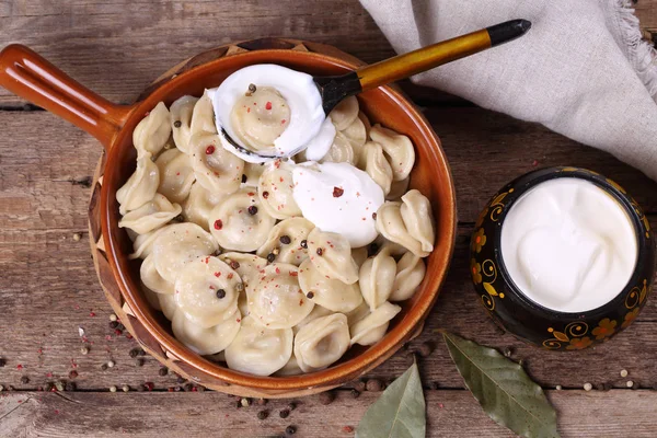 Dumplings med gräddfil i en keramikskål — Stockfoto