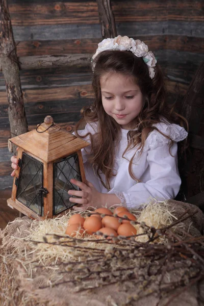 Girl in a wreath holds an old lantern — Stock Photo, Image