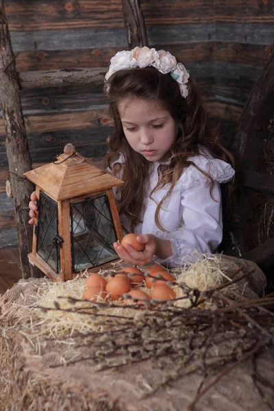 Chica en una corona sosteniendo el huevo en sus manos — Foto de Stock
