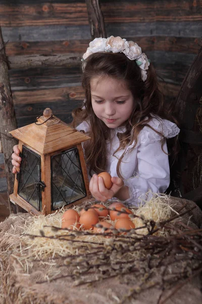 Girl in a wreath holding the egg in his hands — Stock Photo, Image