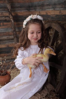 Kız bir çelenk içinde canlı ördek tutar