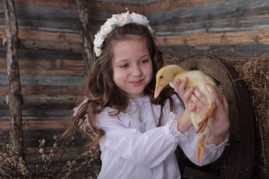 Kız bir çelenk içinde canlı ördek tutar