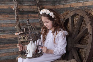 Kız bir kafes ile canlı bir beyaz güvercin tutan bir çelenk