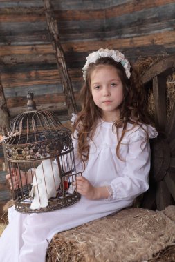 Kız bir kafes ile canlı bir beyaz güvercin tutan bir çelenk