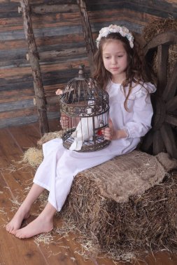 Kız bir kafes ile canlı bir beyaz güvercin tutan bir çelenk