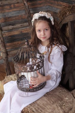 Kız bir kafes ile canlı bir beyaz güvercin tutan bir çelenk