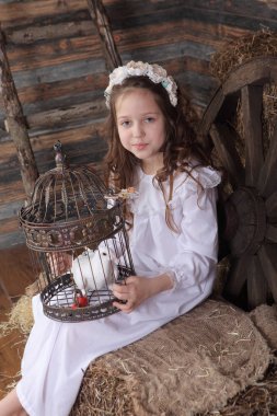 Kız bir kafes ile canlı bir beyaz güvercin tutan bir çelenk