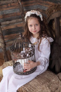 Kız bir kafes ile canlı bir beyaz güvercin tutan bir çelenk