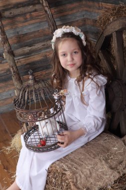 Kız bir kafes ile canlı bir beyaz güvercin tutan bir çelenk