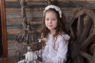 Kız bir kafes ile canlı bir beyaz güvercin tutan bir çelenk