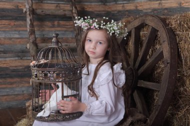 Kız bir kafes ile canlı bir beyaz güvercin tutan bir çelenk