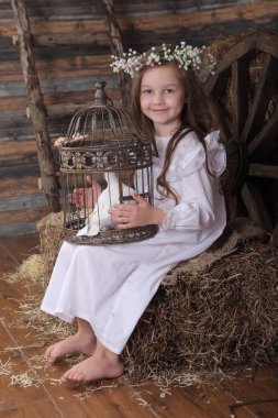 Kız bir kafes ile canlı bir beyaz güvercin tutan bir çelenk