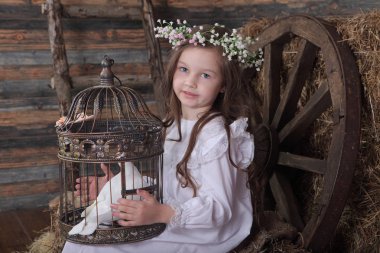 Kız bir kafes ile canlı bir beyaz güvercin tutan bir çelenk