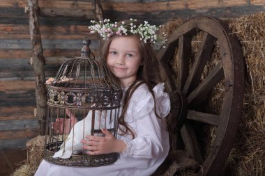 Kız bir kafes ile canlı bir beyaz güvercin tutan bir çelenk