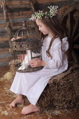 Kız bir kafes ile canlı bir beyaz güvercin tutan bir çelenk