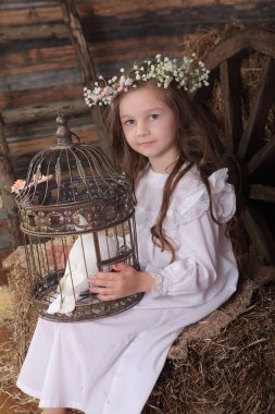 Kız bir kafes ile canlı bir beyaz güvercin tutan bir çelenk