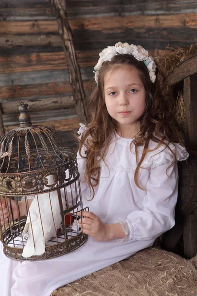 Kız bir kafes ile canlı bir beyaz güvercin tutan bir çelenk